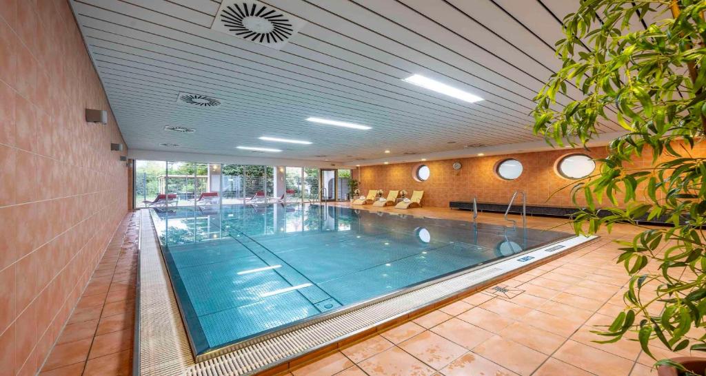 a large swimming pool in a large building at PLAZA INN Heidehof in Hermannsburg