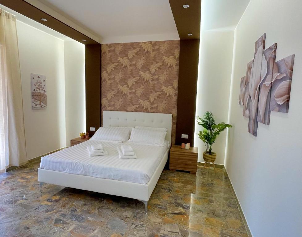 a bedroom with a white bed and a plant at SIS HOUSE Apartment - Deluxe Apartment in Anzio City Center, 100m from the Sea in Anzio