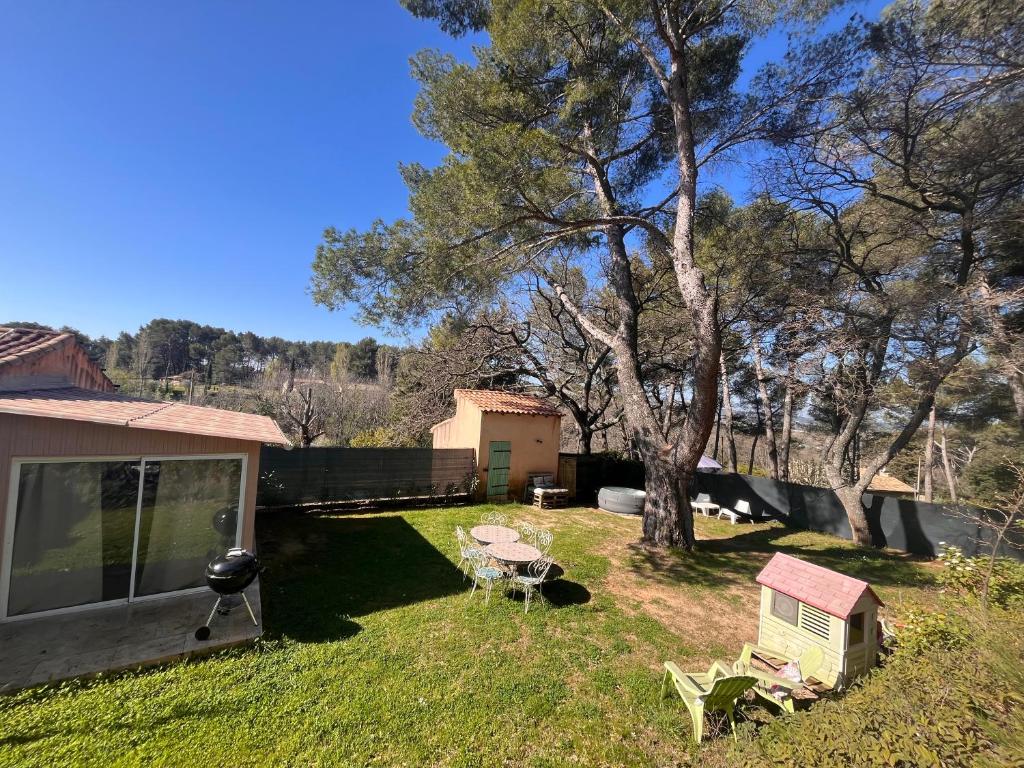 une cour avec une maison, une table et un arbre dans l'établissement Maison provençale au calme de la campagne avec Jacuzzi, à Aix-en-Provence