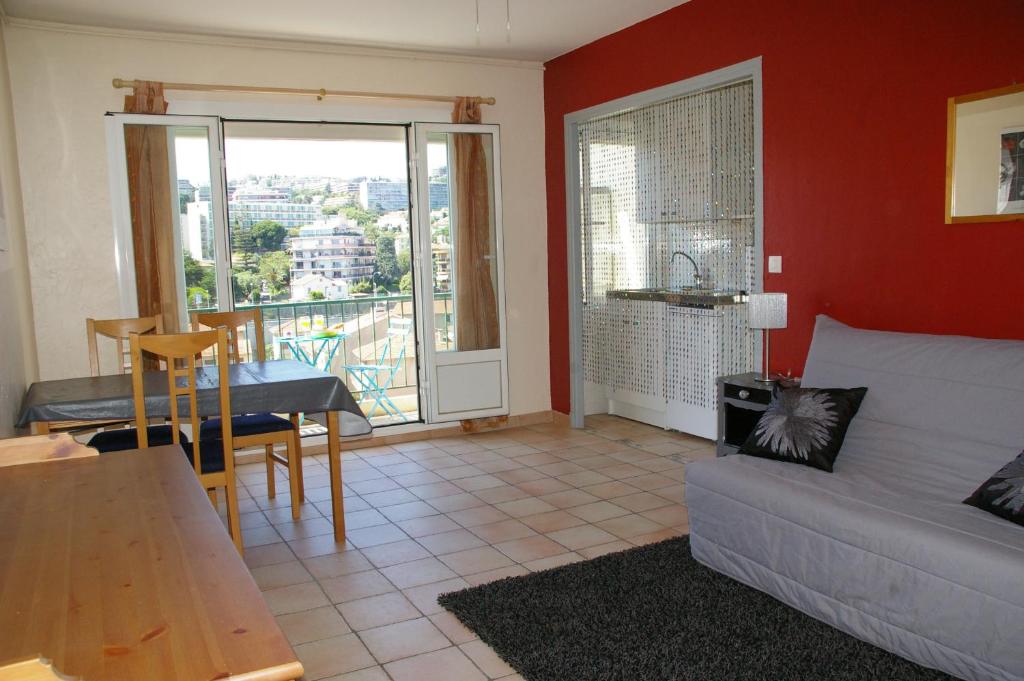 un salon avec un canapé et une table dans l'établissement StudioLAPROM, studio sur la promenade des anglais, à Nice