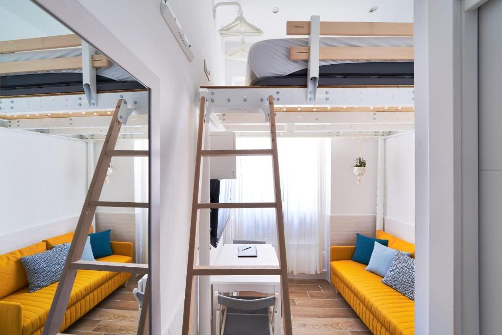 a room with two bunk beds and a couch at MalagaHomeStudio in Málaga