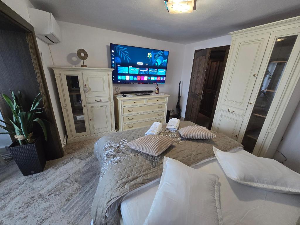 een slaapkamer met een bed en een flatscreen-tv bij OLE Apartment - CENTRAL - Parking included in Timişoara