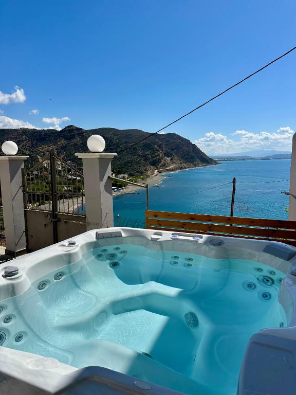 a hot tub on a balcony with a view of the ocean at Irini Panorama in Agia Galini