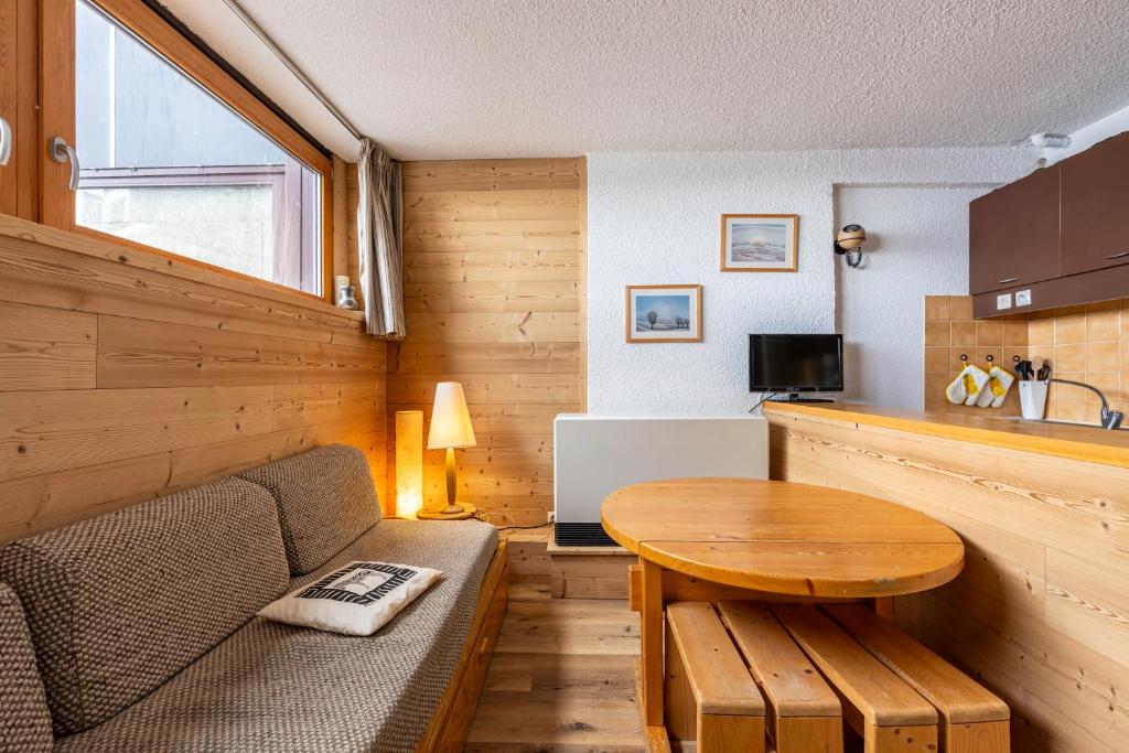 a small living room with a table and a couch at Appartement Aime 2000 in Mâcot La Plagne