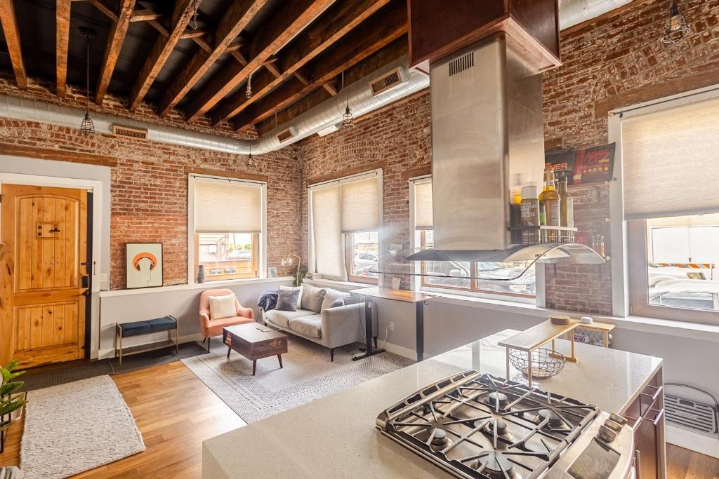 a living room with a brick wall at Stylish SOHO-Inspired Loft, 15 Min to NYC Times Square in Union City