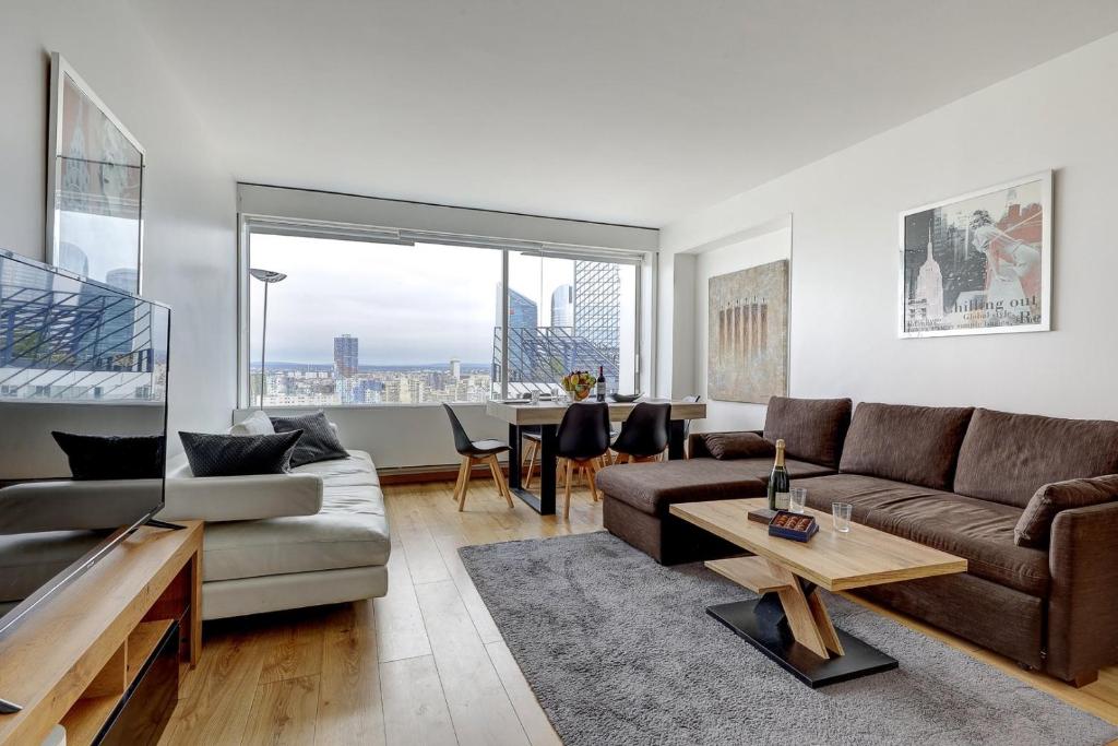 un salon avec un canapé et une table dans l'établissement 5019 Suite Pouey - Apartment near La Défense, à Puteaux