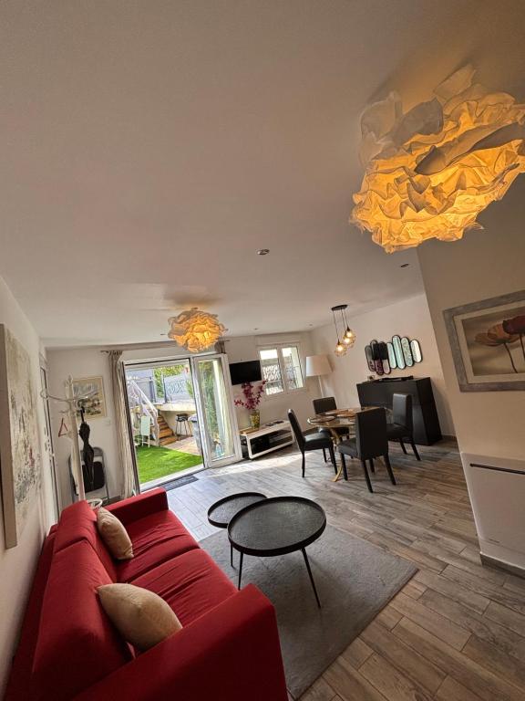 un salon avec un canapé rouge et une table dans l'établissement L Olivier, à Nanterre