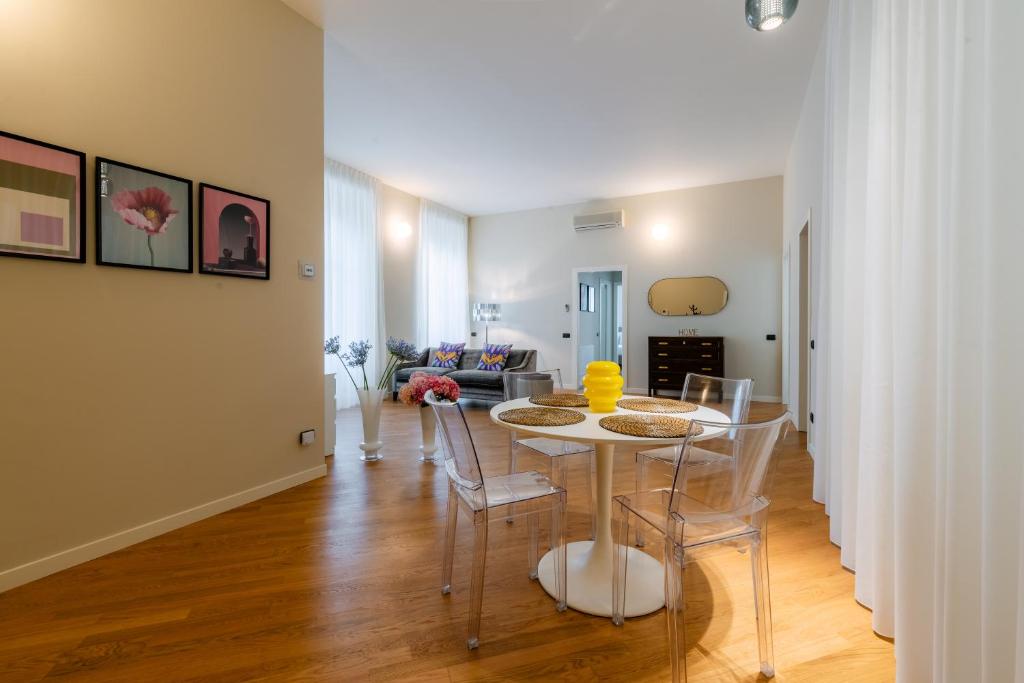 a dining room and living room with a table and chairs at R Oleandro House in Como