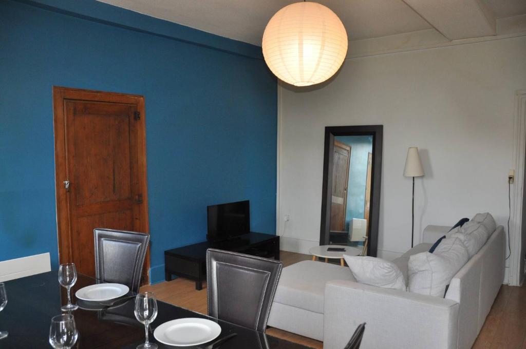 un soggiorno con un divano e un tavolo con sedie di agréable duplex Candé centre ville 4/6 places a Candé