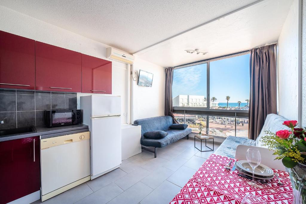 une cuisine et un salon avec vue sur l'océan dans l'établissement Clématite - Vue port climatisé proche plage, à Saint-Cyprien