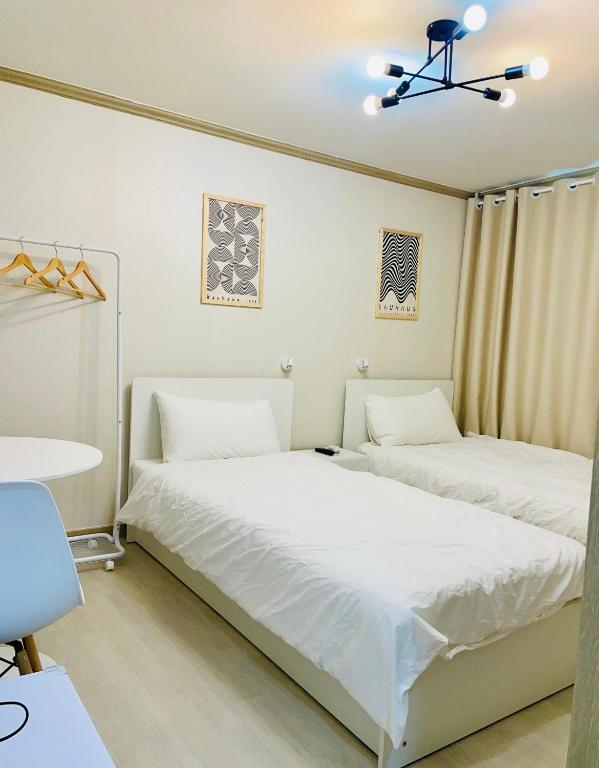 two beds in a room with white walls at Everville, Gaegeum Everville 304 #Stairs to 3rd floor in Busan