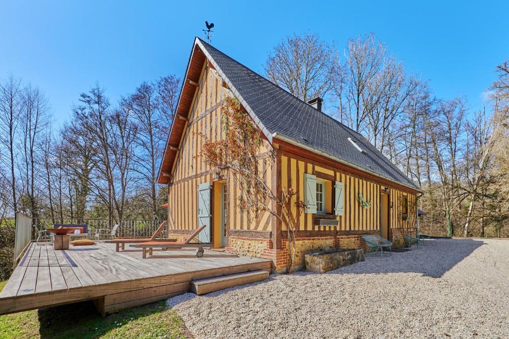 Cette petite cabine dispose d'une terrasse couverte en bois et d'une terrasse en bois. dans l'établissement Le Cottage de la Fontaine Ruante - Grand Jardin, à Saint-Gatien-des-Bois