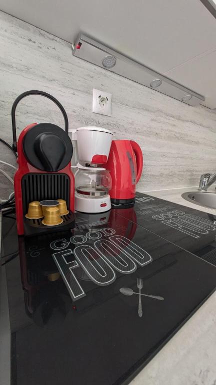 - un comptoir de cuisine avec une cafetière sur une table dans l'établissement L'Ecrin Bleu, Studio lumineux , Wifi & parking, à Villers-sur-Mer