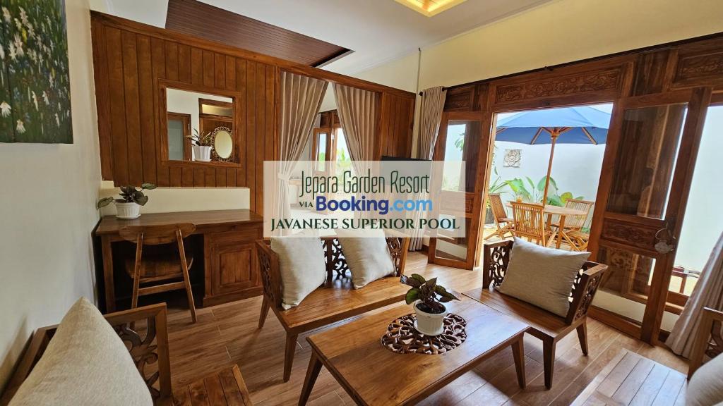 a living room with a table and chairs and a kitchen at Jepara Garden Resort in Jepara