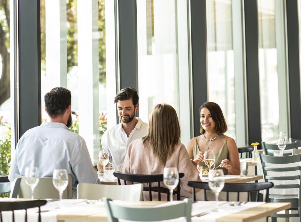 a group of people sitting at a table in a restaurant at Falkensteiner Hotel Park Punat in Punat