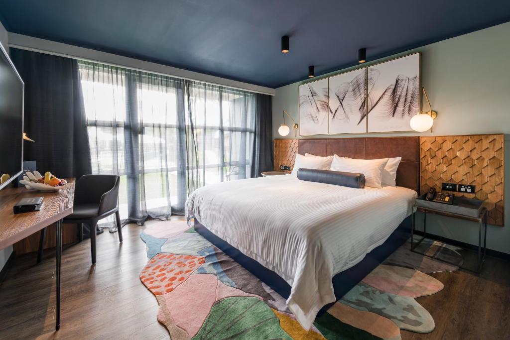 a hotel room with a large bed and a desk at Naumi Auckland Airport Hotel in Auckland