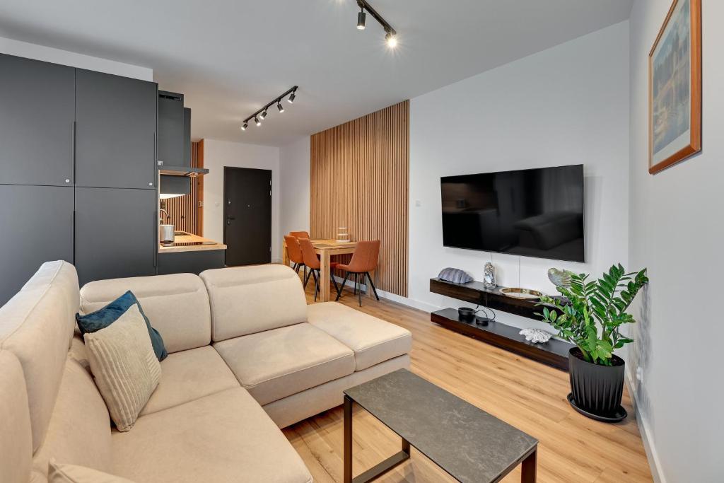 a living room with a couch and a flat screen tv at Comfort Apartments Botanika in Gdańsk