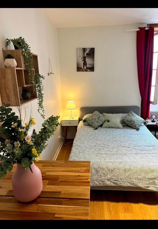 - une chambre avec un lit et un vase avec une plante dans l'établissement Le 6T Gastro, à Dijon