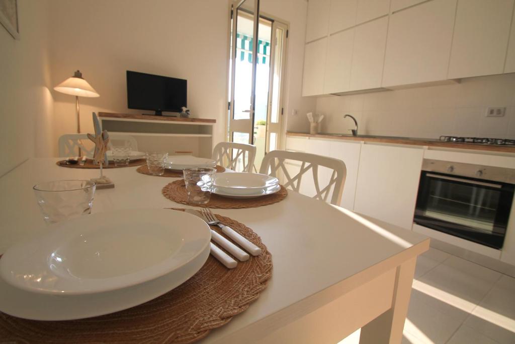 una cucina con tavolo, piatti e utensili di Giada a Baia Verde