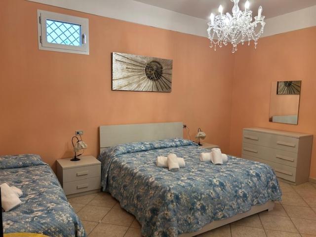 ein Schlafzimmer mit zwei Betten und einem Kronleuchter in der Unterkunft Residence Corona Grossa Balangero in Balangero