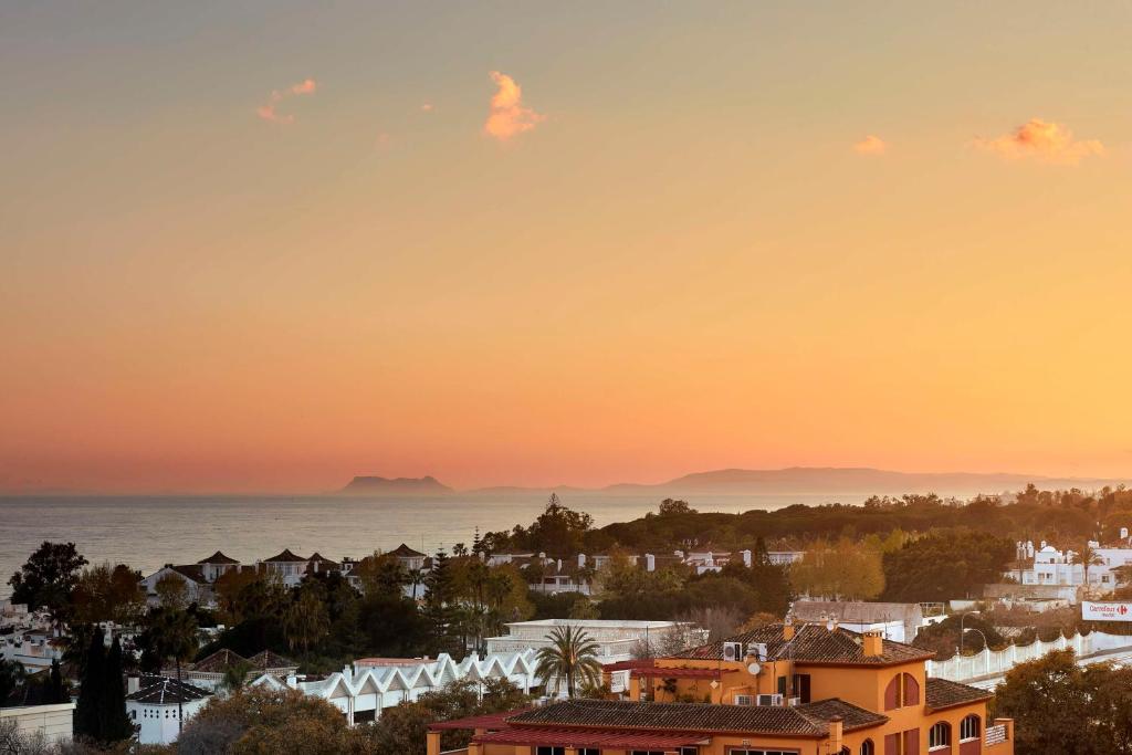 a view of a city with the ocean in the background at NH Collection Marbella in Marbella