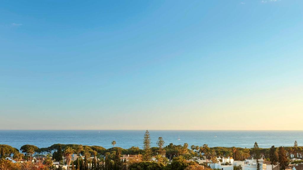 a view of the ocean and a city with trees at NH Collection Marbella in Marbella