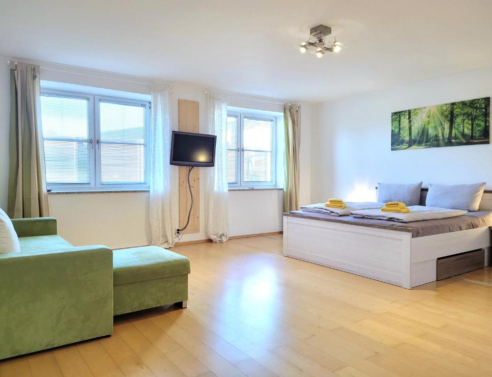 a bedroom with a bed and a tv and a couch at Wohnraum by Steidle in Buxheim