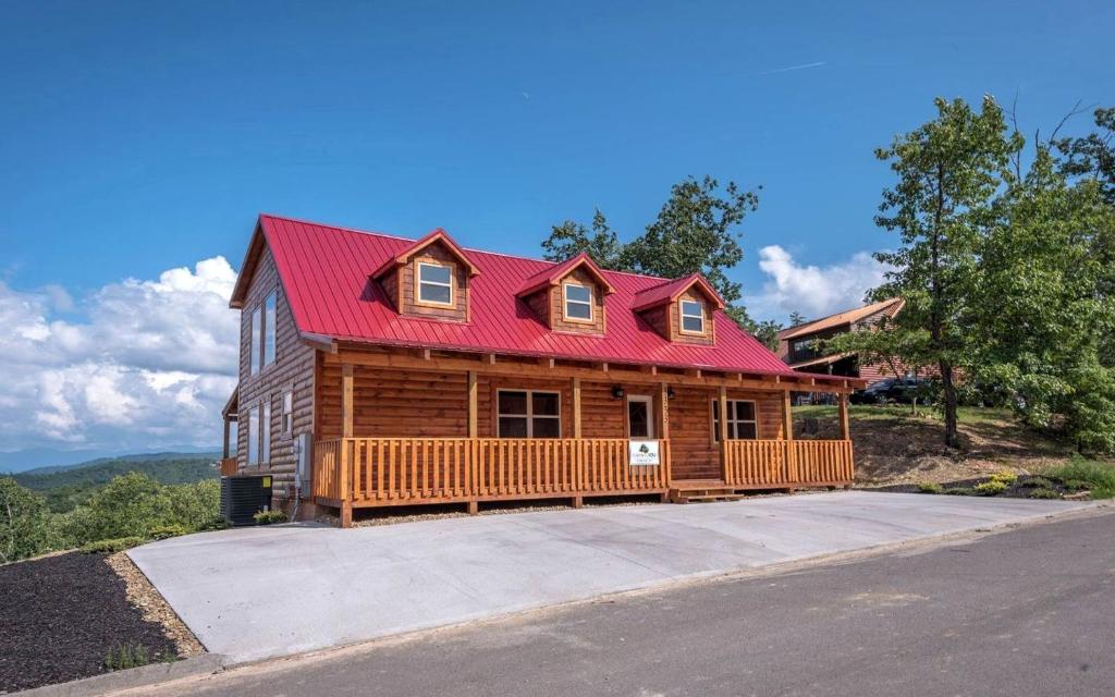 a large log cabin with a red roof at Breathtaking Cabin with Hot-tub, Fireplace and Games in Sevierville, Tennessee in Little Cove