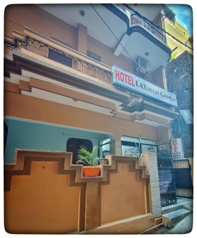 a hotel lobby with a potted plant on the stairs at Hotel Laxman Ganga in Rishīkesh