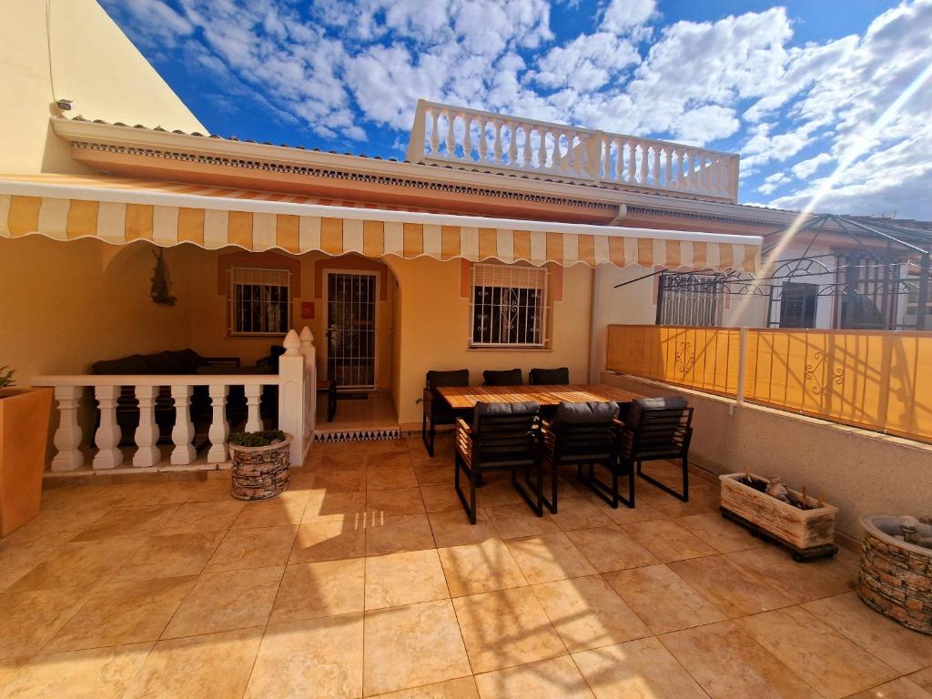 un patio avec une table et des chaises sur un balcon dans l'établissement Tranquil Bungalow Retreat, à Ciudad Quesada
