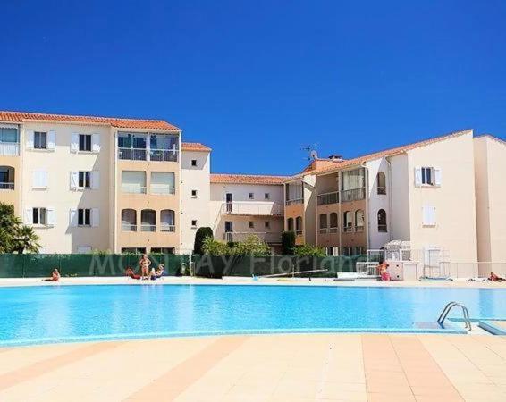 une piscine devant certains immeubles d'habitation dans l'établissement Le lagon bleu piscine et tennis, à Fréjus