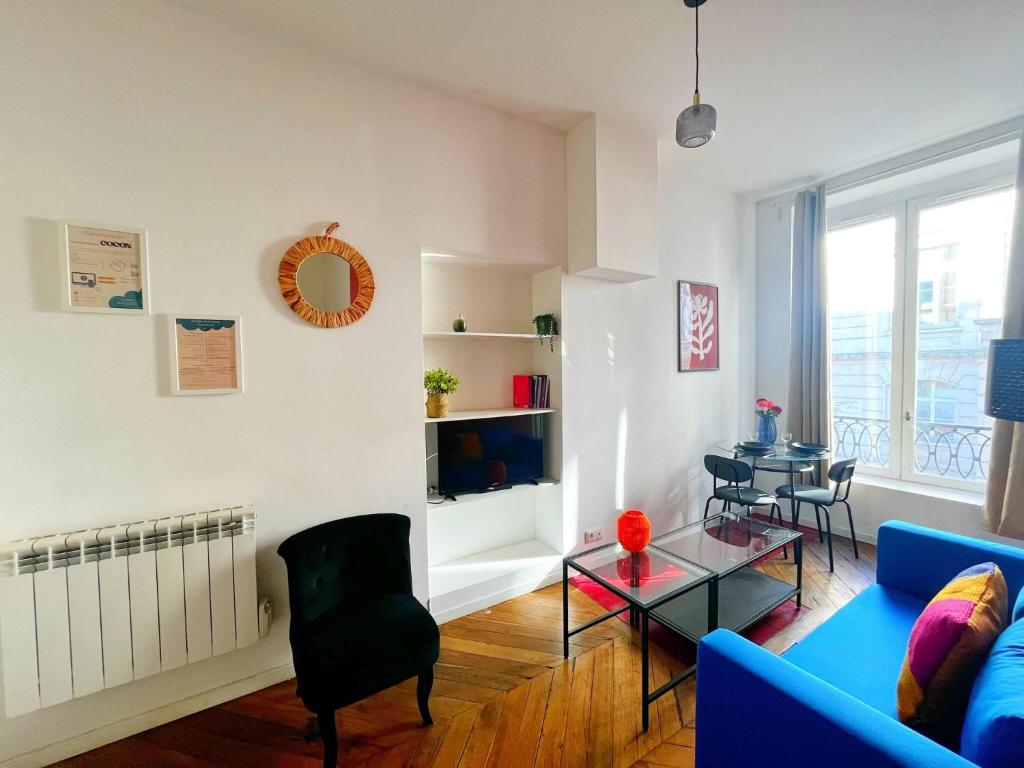 un salon avec un canapé bleu et une table dans l'établissement Suite Brandy - Check in h24 - proche gare de Vaise, à Lyon