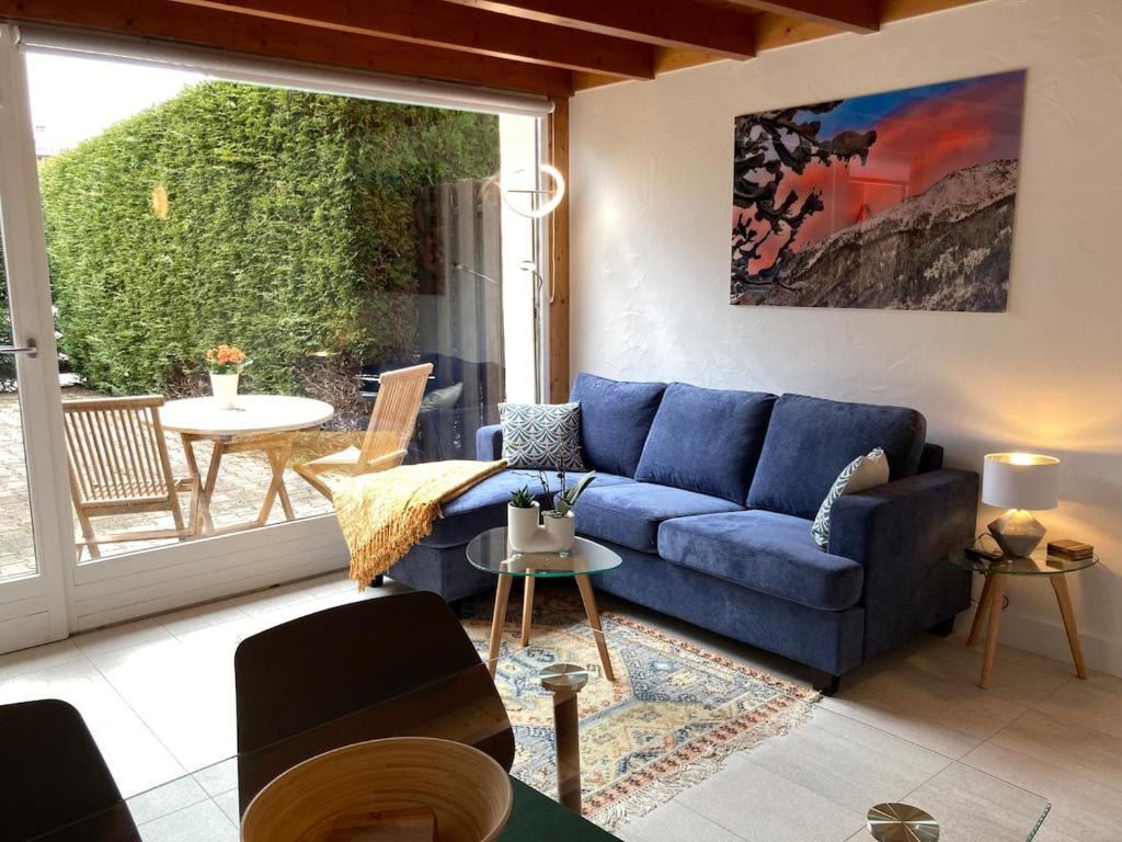 un salon avec un canapé bleu et une table dans l'établissement Chamonix Centre - Sophisticated 2-Bedroom Duplex, à Chamonix-Mont-Blanc