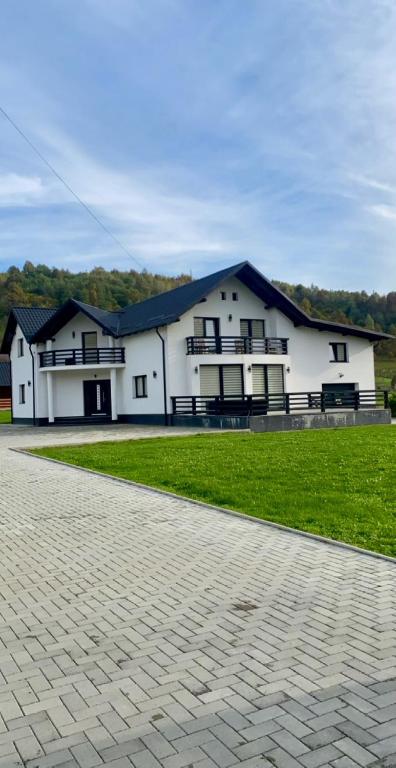 a white building with a black roof and grass at Casa Florus in Şieu