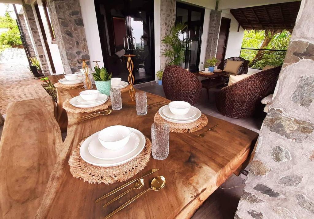 a wooden table with plates on top of it at English Cottage House Tagaytay in Calaca