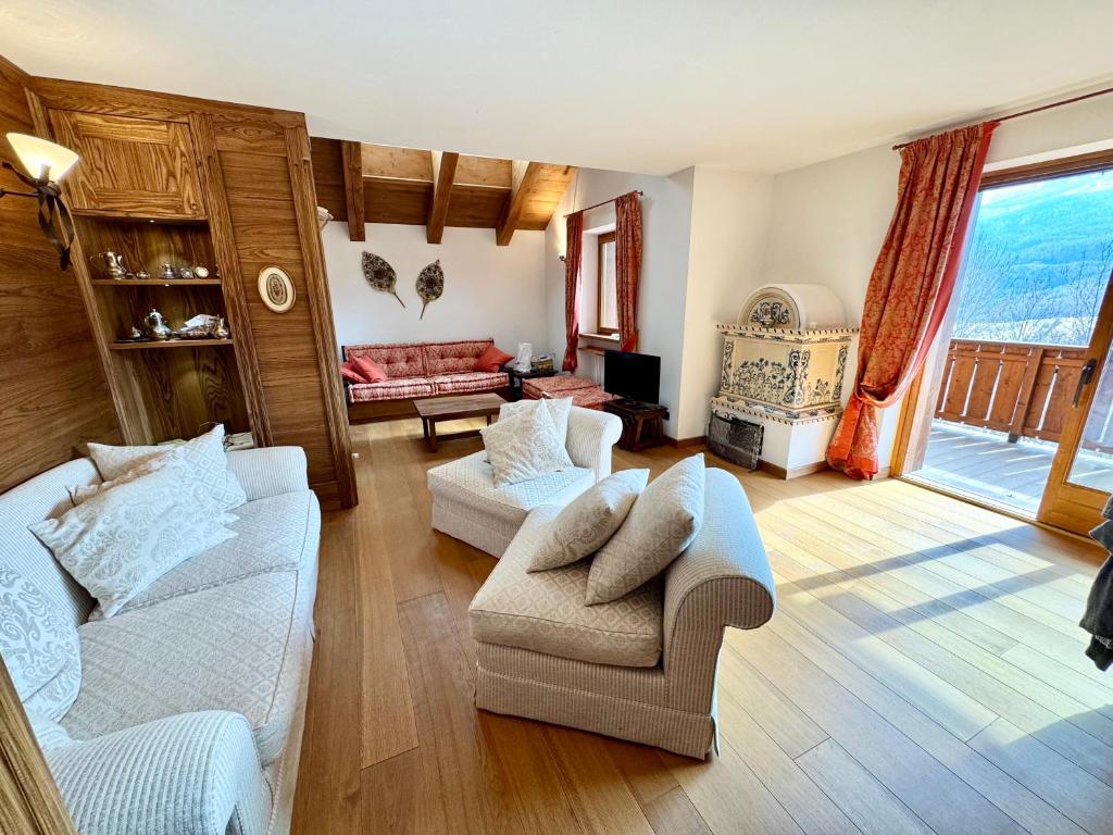 a living room with two white couches and a fireplace at Charme alpino e modernità-Appartamento ristrutturato a due passi dal centro in Cortina dʼAmpezzo