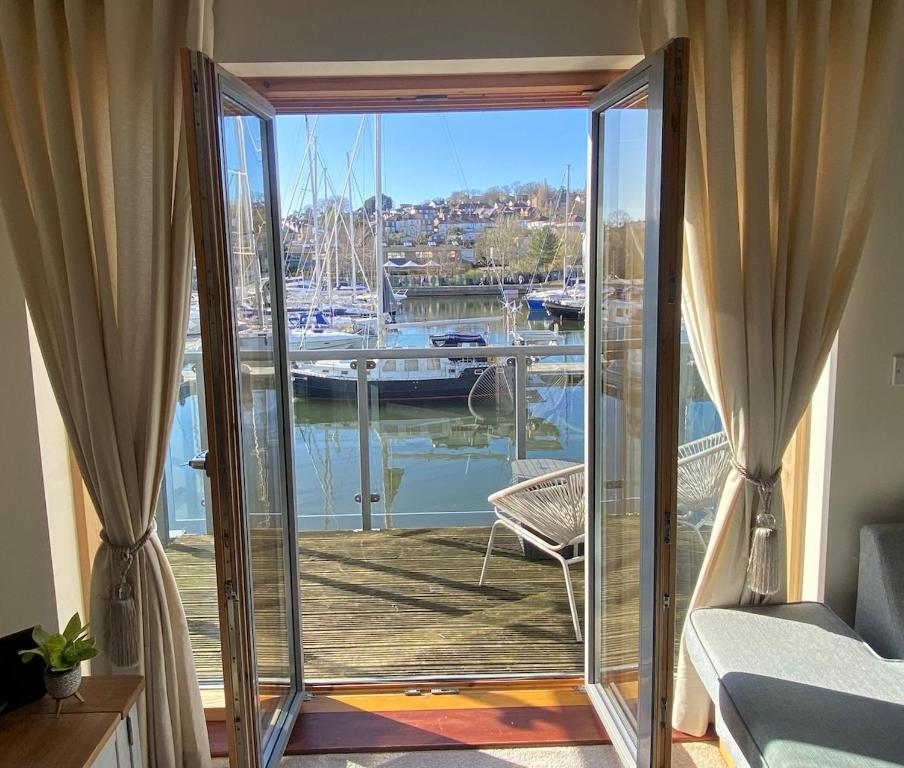 a bedroom with a balcony with a view of a marina at Stunning Marina Apartment in Portishead