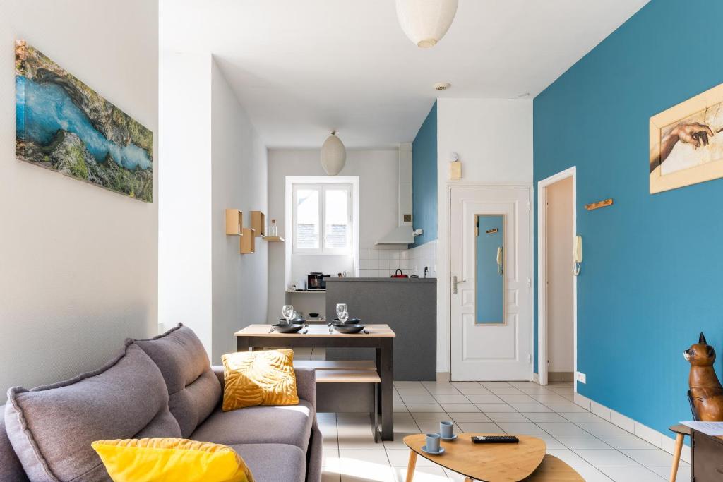 a living room with a couch and a kitchen at nid douillet 4places 2lits cœur de ville logement Hote-Zen wifi in Segré