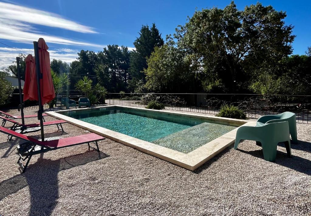 - une petite piscine avec une chaise et un parasol dans l'établissement Royantine, à Aubagne