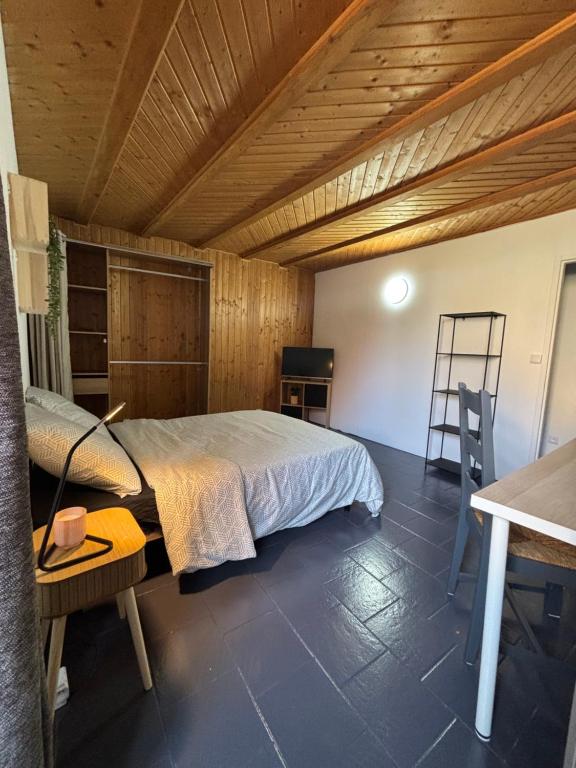 une chambre avec un lit et un plafond en bois dans l'établissement La Grange du Tanneur, à Fraroz