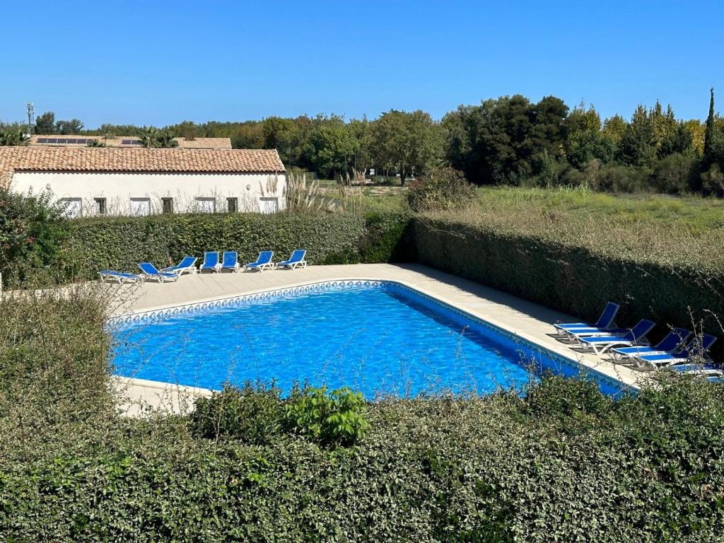 une piscine avec des chaises et une maison dans l'établissement L'ECUME DES VAGUES- Spacieux 3 chambres Familial Tout Confort au Calme, Climatisé et Piscine, adapté au télétravail, à Saint-Cyprien