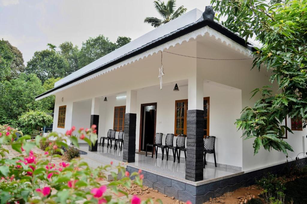 a small house with a porch at Navaratna Holiday Homestay in Vagamon