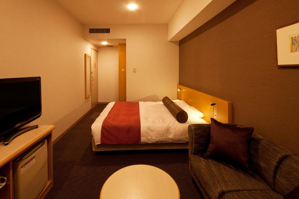 a hotel room with a bed and a tv at Ueda Tokyu REI Hotel in Ueda