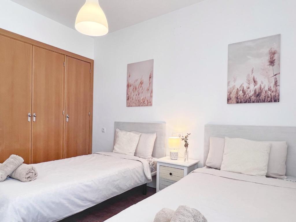 A bed or beds in a room at A Levante Conil- Solo familias y parejas
