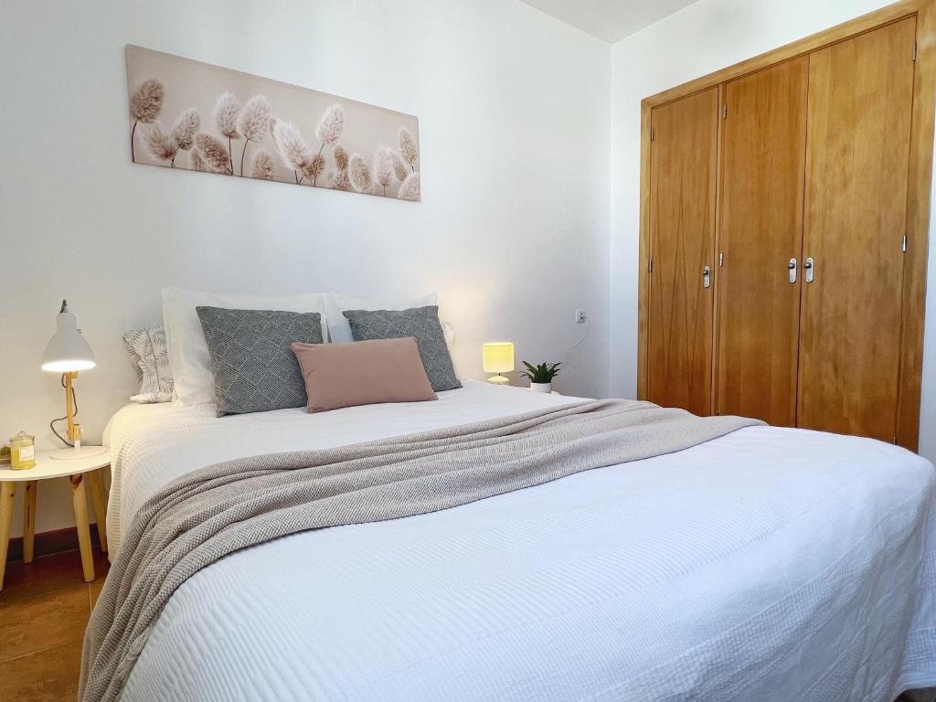 A bed or beds in a room at A Levante Conil- Solo familias y parejas