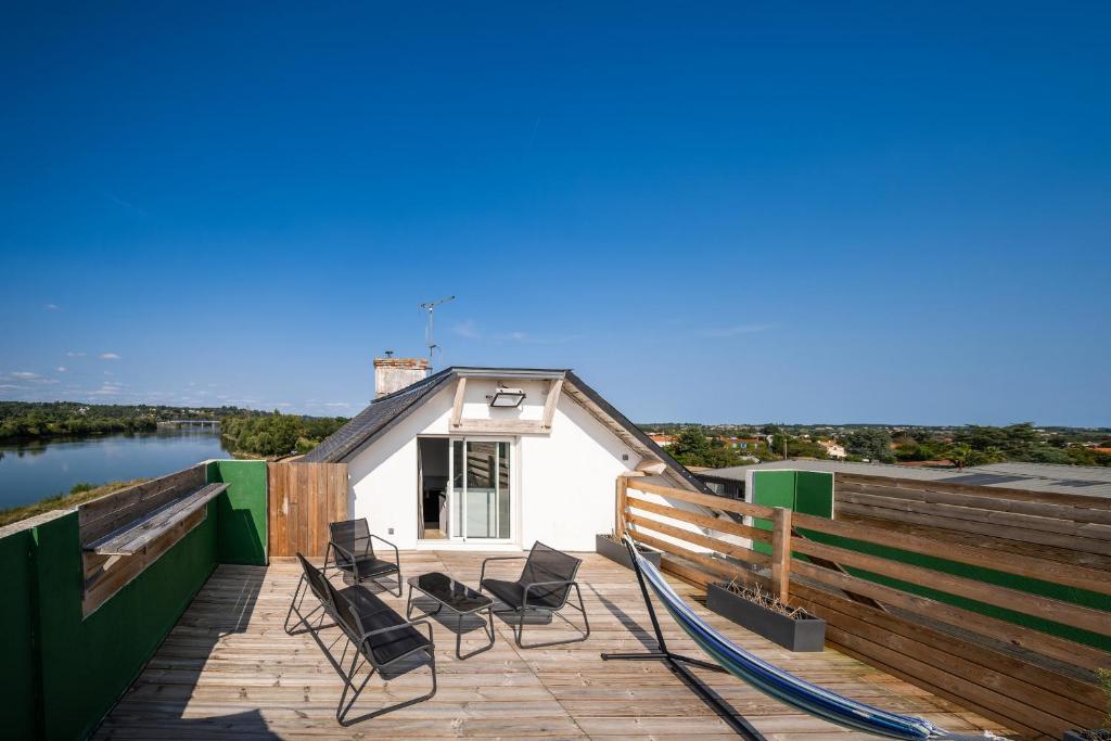 un groupe de chaises assises sur une terrasse à côté d'un bâtiment dans l'établissement gite pierre percée bord de Loire proche Nantes, à Divatte sur Loire