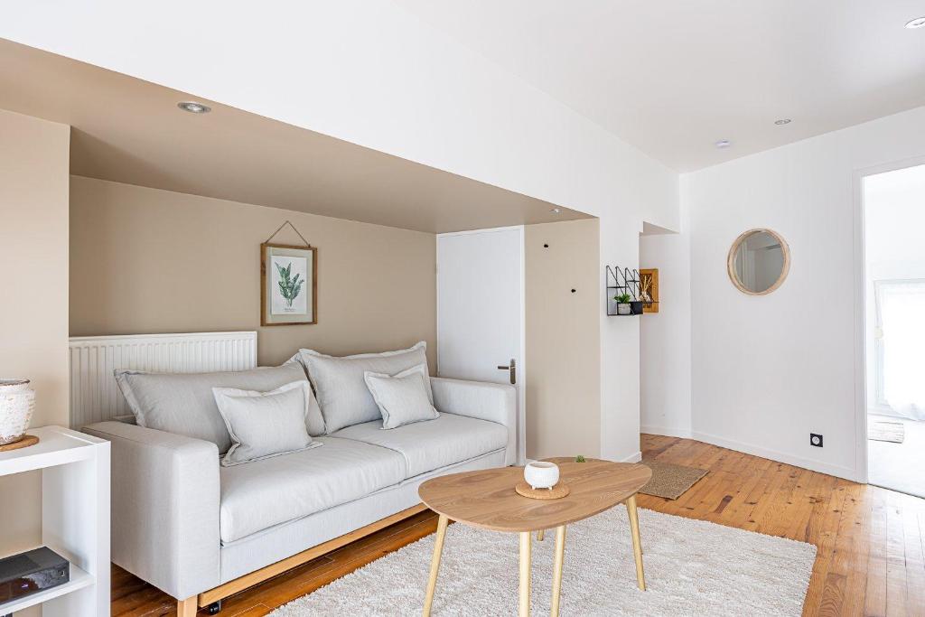 un salon avec un canapé blanc et une table dans l'établissement OIQIA • Téralis • Équinoxe, à Annonay