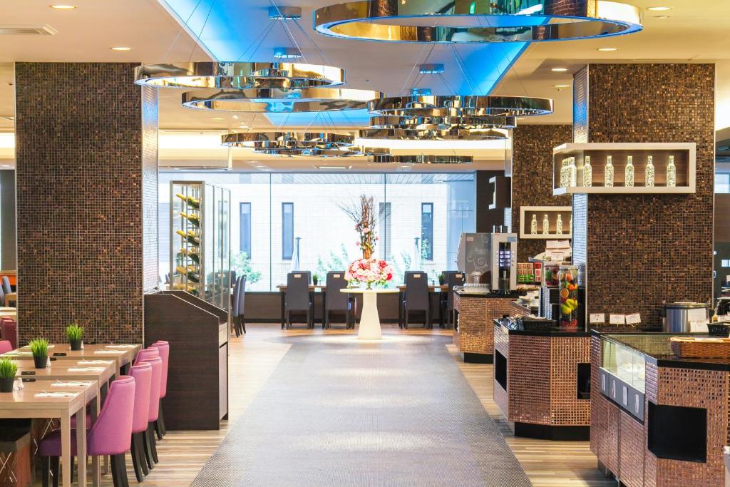 a restaurant with pink chairs and tables and a blue ceiling at Shin Yokohama Prince Hotel in Yokohama
