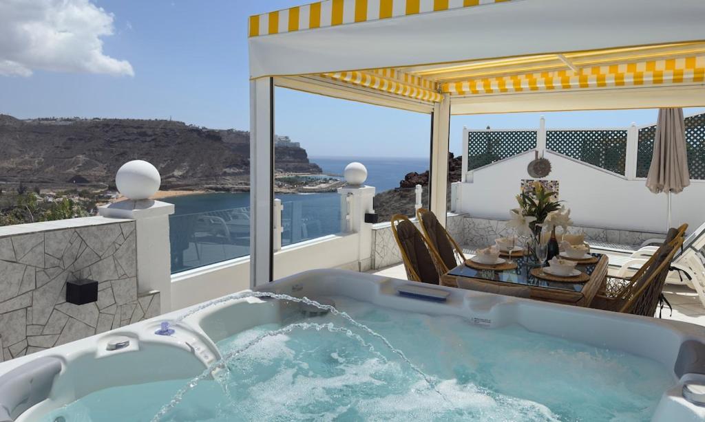 un jacuzzi en un patio con una mesa en Bella Vista - Jacuzzi with amazing sea views, en Playa del Cura