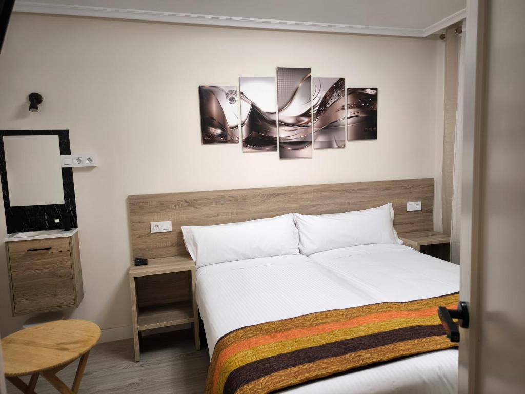 オビエドにあるHostal del Norteのベッドルーム1室(ベッド1台付)が備わります。壁には絵画が飾られています。